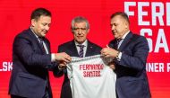 Newly appointed head coach of the Polish national football team Fernando Santos (centre), the secretary general of Polish Football Association Lukasz Wachowski (left) and the president of the Polish Football Association Cezary Kulesza pose with a shirt bearing the name of Fernando Santos during his presentation to the press at the national stadium in Warsaw, on January 24, 2023. (Photo by Wojtek RADWANSKI / AFP)