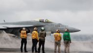 Crew members signal to a F/A-18E Super Hornet fighter jet preparing to take off for a routine flight on board the U.S. USS Nimitz aircraft carrier during a routine deployment to the South China Sea, Mid-Sea, on January 27, 2023. REUTERS/Joseph Campbell/File Photo
