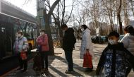 People wait at a bus stop in Beijing's Central Business District (CBD), during the morning rush hour following the Chinese Lunar New Year holiday, in Beijing, China January 30, 2023. REUTERS/Tingshu Wang