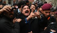 Police officials escort Pakistan's former interior minister Sheikh Rashid Ahmed (centre) to present him before a court in Islamabad on February 2, 2023. (Photo by Aamir Qureshi / AFP)