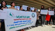 Iraqi women's rights activists lift placards during a rally near the Supreme Judicial Council in Baghdad on February 5, 2023, to protest the killing of Iraqi youtuber Tiba al-Ali by her father in Diwaniyah. (Photo by AHMAD AL-RUBAYE / AFP)