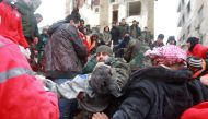 Syrian rescue teams carry a casualty picked up from the rubble after an earthquake in the government-controlled central Syrian city of Hama on February 6, 2023. - A 7.8-magnitude earthquake hit Turkey and Syria early on February 6, killing hundreds of people as they slept, levelling buildings and sending tremors that were felt as far away as the island of Cyprus, Egypt and Iraq. (Photo by LOUAI BESHARA / AFP)