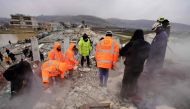 White Helmet rescue workers search for victims and survivors in the rubble of collapsed buildings, following an earthquake in the town of Sarmada in the countryside of the northwestern Syrian Idlib province, early on February 6, 2023.  (Photo by MUHAMMAD HAJ KADOUR / AFP)