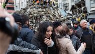 A woman reacts as rescuers search for survivors through the rubble of collapsed buildings in Adana, on February 6, 2023. Photo by Can EROK / AFP
