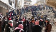 Rescuers search the rubble of buildings for casualties and survivors in the village of Salqin in Syria's rebel-held northwestern Idlib province at the border with Turkey following an earthquake, on February 7, 2023. (Photo by Omar HAJ KADOUR / AFP)