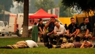 Firefighters rest at the command post after fighting forest fires in Santa Juana, Concepcion province, Chile on February 6, 2023.  (Photo by JAVIER TORRES / AFP)