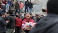  A Syrian man carries the body of a child on February 7, 2023, Photo by Bakr ALKASEM / AFP
