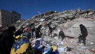 People search for missing relatives in the rubble of a collapsed building in the southeastern Turkish city of Kahramanmaras, on February 8, 2023, two days after a strong earthquake struck the region. (Photo by OZAN KOSE / AFP)