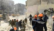 Armenian rescuers (orange helmet) and Syrian soldiers sift through the rubble of a collapsed building in the northern city of Aleppo, searching for victims and survivors days after a deadly earthquake hit Turkey and Syria, on February 9, 2023. (Photo by AFP)