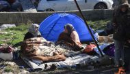 Two women sit next to a tent in Nurdagi, in the countryside of Gaziantep, on February 9, 2023, three days after a deadly earthquake that hit Turkey and Syria. (Photo by Zein Al Rifai / AFP)