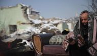 A man sits in front of his collapsed building as rescue teams carry out search operations at Elbistan district of Kahramanmaras on February 11, 2023, after a 7.8-magnitude earthquake struck the country's southeast earlier in the week. (Photo by OZAN KOSE / AFP)