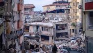 A Turkish soldier walks among destroyed buildings in Hatay, on February 12, 2023, after a 7.8-magnitude earthquake struck the country's south-east. (Photo by Yasin Akgul / AFP)