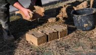 Master builder Janos Gaspar explains the making of bricks of a mud-brick house in Acs, northwestern Hungary, on November 25, 2022. Photo by ATTILA KISBENEDEK / AFP