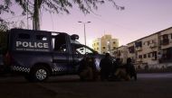 Security personnel take position behind a police vehicle near site of an attack to a police compound in Karachi on February 17, 2023. - A gunbattle was raging on February 17 night inside a Pakistan police building in the port city of Karachi, an AFP correspondent near the scene said. (Photo by Asif HASSAN / AFP)