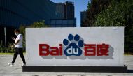 This file photo taken on September 6, 2022 shows an employee walking past the company logo at Baidu's headquarters in Beijing. Photo by Jade GAO / AFP