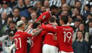 Manchester United's Brazilian midfielder Casemiro celebrates with teammates after scoring the opening goal of the English League Cup final football match between Manchester United and Newcastle United at Wembley Stadium, north-west London on February 26, 2023. (Photo by ADRIAN DENNIS / AFP)