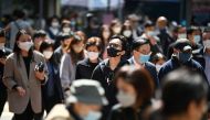 People wear masks on a street in Hong Kong on February 27, 2023 as health experts in the territory backed the extension of its mask mandate to March 8 leaving Hong Kong as one of the only places left in the world with such rules. (Photo by Peter PARKS / AFP)