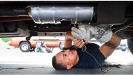 Deputy Jaime Moran from the Los Angeles Sheriffs Department engraves the catalytic converter of a vehicle with a traceable number on July 14, 2021, in City of Industry, California. File photo / AFP

