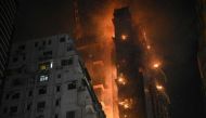 A fire burns at a high-rise building under construction in the Tsim Sha Tsui district in Hong Kong on March 3, 2023. Photos by Peter PARKS / AFP