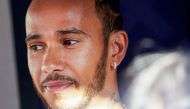 Mercedes' British driver Lewis Hamilton arrives in the paddock at the Bahrain International Circuit in Sakhir ahead of the Bahrain Formula One Grand Prix on March 2, 2023. (Photo by Giuseppe CACACE / AFP)

