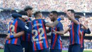Barcelona's Brazilian forward Raphinha celebrates with teammates scoring his team's first goal during the Spanish League match between FC Barcelona and Valencia CF at the Camp Nou stadium in Barcelona on March 5, 2023. (Photo by Josep LAGO / AFP)