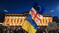 A protesters wave the Georgian, Ukrainian and European flags during a demonstration called by Georgian opposition and civil society groups outside Georgia's Parliament in Tbilisi on March 8, 2023.  (Photo by Vano SHLAMOV / AFP)