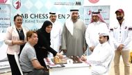 Qatar Chess Association President Mohamed Al Mudhahka, members of QCA and Dr. Eiman Al Ansari, AAB Government Relations and Public Affairs Director with players during the opening game of the tournament.