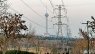 People walk at the Pardisan park with a view of the Milad tower in Tehran, on March 12, 2023. (Photo by Atta Kenare / AFP)