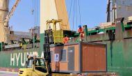 Workers load cabins and caravans used during the football World Cup in Qatar onto a cargo ship slated for departure from Hamad Port, on March 20, 2023, as a donation to Turkey and Syria to house people who lost their homes in a devastating earthquake in early February. (Photo by KARIM JAAFAR / AFP)