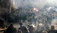 Tear gas fumes fill the air as retired Lebanese army and security forces veterans attempt to break into the government palace premises in the centre of Beirut on March 22, 2023 . (Photo by Joseph Eid / AFP)