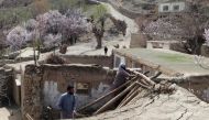 Residents remove debris from the rooftop of damaged a house at Sooch village in Jurm district of Badakhshan Province on March 22, 2023, following an overnight earthquake. (Photo by Omer Abrar / AFP)