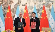 Honduras Foreign Minister Eduardo Enrique Reina (left) and Chinese Foreign Minister Qin Gang pose with documents following the establishment of diplomatic relations between the two countries, at a ceremony in the Diaoyutai State Guesthouse in Beijing on March 26, 2023. (Photo by GREG BAKER / AFP)