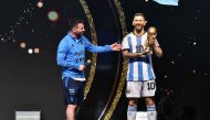 Argentina's forward Lionel Messi looks at a statue of himself during a tribute by Conmebol to the members of the Argentine national team for winning the Qatar 2022 World Cup, before the draw of the group phases of the Libertadores and Sudamericana football tournaments, at Conmebol's headquarters in Luque, Paraguay, on March 27, 2023. Photo by NORBERTO DUARTE / AFP