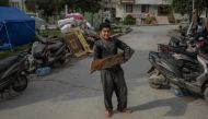 A Syrian boy carries woods for a bakery in the centre of Hatay, on March 28, 2023, after a 7.8-magnitude earthquake on February 6, 2023 killed more than 50,000 in southeastern Turkey and nearly 6,000 over the border in Syria, leaving entire cities in ruins. (Photo by BULENT KILIC / AFP)