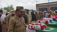 Relatives and security officials gather around the coffins of policemen who were killed by a roadside bomb in Lakki Marwat district of Khyber Pakhtunkhwa province on March 30, 2023.  (Photo by Marwat AKBAR / AFP)