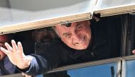 Former Brazilian president Jair Bolsonaro greets supporters from a window at the Liberal Party headquarters of n Brasilia on March 30, 2023. (Photo by EVARISTO SA / AFP)