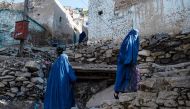 :Afghan burqa-clad women climb a stony path in the Sh?r B?z?r area of Kabul on April 6, 2023. (Photo by Wakil KOHSAR / AFP)
