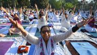 People practice yoga during the morning at a park in Amritsar in the northwestern Indian state of Punjab on April 9, 2023. (Photo by Narinder Nanu / AFP)