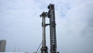 Workers in lifts prepare the SpaceX Starship ahead of the scheduled launch from the SpaceX Starbase in Boca Chica, Texas on April 19, 2023. Photo by Patrick T. Fallon / AFP