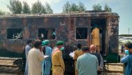 Security officials search for victims inside a burnt out carriage following an overnight fire in the Karachi Express passenger train near Sukkur, some 450 km north of the port city of Karachi on April 27, 2023. Photo by Shahid ALI / AFP