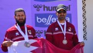 Qatar team members pose with the national flag.  