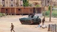 Sudanese Army sodliers walk near tanks stationed on a street in southern Khartoum, on May 6, 2023, amid ongoing fighting against the paramilitary Rapid Support Forces. Photo by AFP