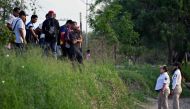 Members of the Beta Group of the Mexican Government (R) instruct migrants not to cross the Rio Bravo river (Rio Grande in the US) into the US, in the border city of Matamoros, Tamaulipas State, Mexico, on May 10, 2023. (Photo by Alfredo ESTRELLA / AFP)
