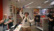 First customer David Castillo wields the Master Sword as he poses for a photo after purchasing 