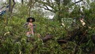 A woman stands amid fallen trees in Kyauktaw in Myanmar's Rakhine state on May 14, 2023 after Cyclone Mocha made landfall.  (Photo by Sai Aung MAIN / AFP)