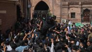 Security personnel and supporters of former prime minister Imran Khan gather around his vehicle upon his arrival in High court in Lahore on May 15, 2023. (Photo by Arif Ali / AFP)
 