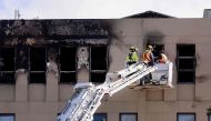 Firefighters inspect the Loafers Lodge hostel where a fire broke out a day earlier in the suburb of Newtown in Wellington on May 17, 2023. Photo by Marty MELVILLE / AFP