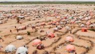 This aerial view shows makeshift structures of people displaced by drought at the Ladan internally displaced people (IDP) camp in Dolow on May 1, 2023. (Photo by Hassan Ali Elmi / AFP)
