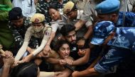 Indian wrestlers Vinesh Phogat (C) with others are detained by the police while attempting to march to India's new parliament, just as it was being inaugurated by Prime Minister Narendra Modi, in New Delhi on May 28, 2023. (Photo by Arun Thakur / AFP)