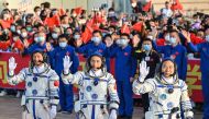 Gui Haichao (L) payload expert, Zhu Yangzhu (C) space flight engineer and commander Jing Haipeng (R) wave during the seeing-off ceremony on May 30, 2023. (Photo by Hector Retamal / AFP)
